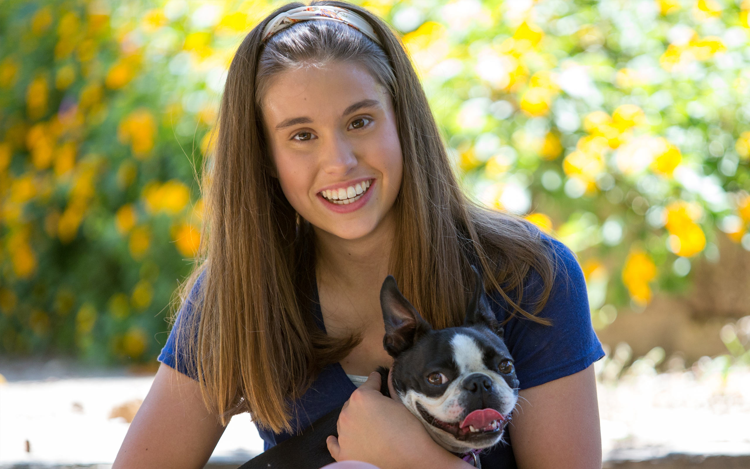 Julia, diagnosed with aHUS at 15 years old, holding a dog
